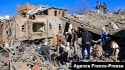 Yemenis inspect the damage following overnight air strikes by the Saudi-led coalition targeting the Huthi rebel-held capital Sanaa, Jan. 18, 2022. 