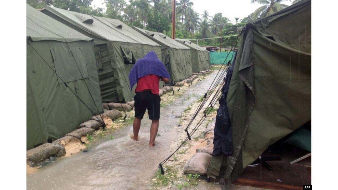FILE - A man walking between tents at Australia's regional processing centre on Manus Island, in Papua New Guinea.