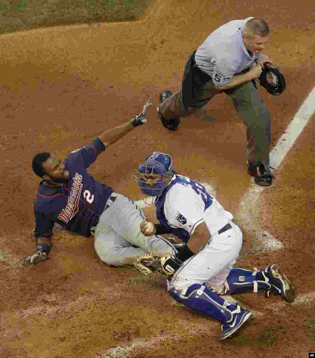 Minnesota Twins' Denard Span (2) looks for the call from home plate umpire Mike Everitt, top right, after being forced out at home by Kansas City Royals catcher Brayan Penawhile trying to stretch a triple during the fourth inning of a baseball game on Fri
