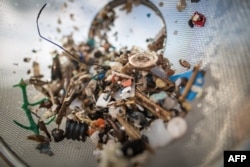 Seorang relawan dari LSM “Canarians Libre de Plasticos” (Kepulauan Canary bebas plastik) menunjukkan sampah mikroplastik dan mesoplastik saat membersihkan pantai Almaciga, di Tenerife, pesisir utara Kepulauan Canary, 14 Juni 2018.