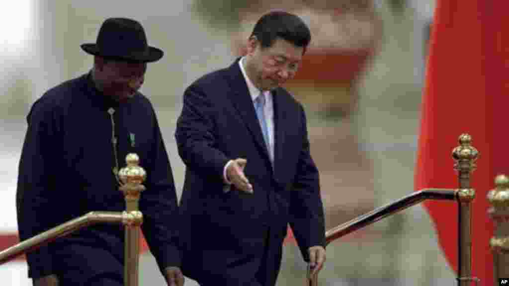 Chinese President Xi Jinping gestures to President Jonathan as they walk together during a welcome ceremony at the Great Hall of the People in Beijing, China.