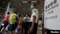 Arriving flight passengers go through a temperature check at Hong Kong Airport as a cautionary measure against Middle East Respiratory Syndrome, June 5, 2015.