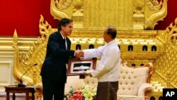 Myanmar President Thein Sein, right, shakes hands with U.S. Deputy Secretary of State Antony Blinken, left, as he presents gift during their meeting at Presidential Palace, May 21, 2015, in Naypyitaw, Myanmar.
