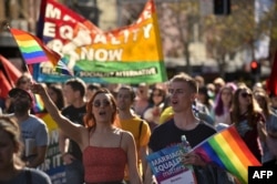 Supporters of same-sex marriage carry banners and shout slogans as they march in Sydney, Australia, Aug. 6, 2017.