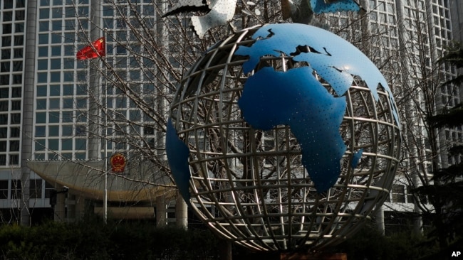 Tư liệu: Tác phẩm điêu khắc quả địa cầu bên ngoài Bộ Ngoại giao ở Bắc Kinh, ngày 18/3/2020. Ít nhất 13 phóng viên Mỹ chờ bị trục xuất khỏi TQ, trả đũa quyết định của Mỹ hạn chế thị thực đối với truyền thông nhà nước TQ hoạt động tại Hoa Kỳ. (AP Photo/Andy Wong)