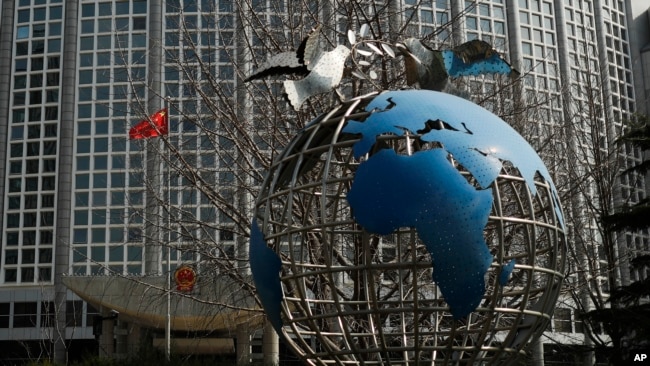 资料照片: 中国外交部大楼前的地球仪与和平鸽。（2020年3月18日）