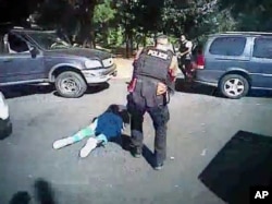 This image made from video provided by the Charlotte-Mecklenburg Police Department, Sept. 24, 2016, shows Keith Scott on the ground as police approach him in Charlotte, N.C., on Sept. 20, 2016.