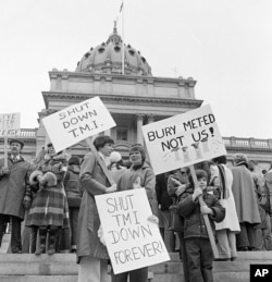 Two mothers along with their children carry signs to close the TMI nuclear plant in front of the State Capitol in Harrisburg, Penn. on April 8, 1979.