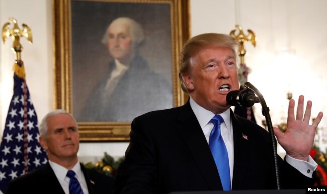 U.S. Vice President Mike Pence listens as U.S. President Donald Trump announces that the United States recognizes Jerusalem as the capital of Israel and will move its embassy there, during an address from the White House, Dec. 6, 2017.