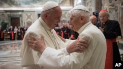 Pope Francis, left, and retired Pope Benedict XVI embrace during a ceremony to celebrate Benedict's 65th anniversary of his ordination as a priest, in the Clementine Hall of the Apostolic Palace, at the Vatican, June 28, 2016. 