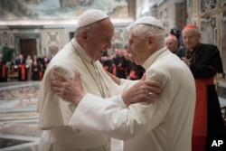 FILE - Pope Francis, left, and retired Pope Benedict XVI embrace during a ceremony to celebrate Benedict's 65th anniversary of his ordination as a priest, in the Clementine Hall of the Apostolic Palace, at the Vatican, June 28, 2016.
