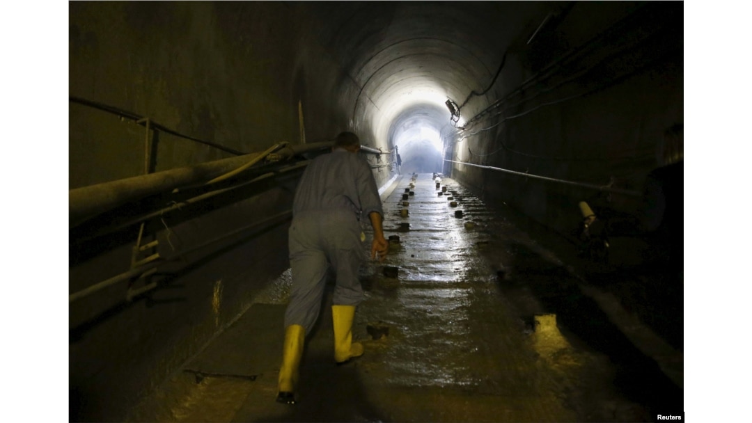 FILE - A laborer walks as he works at strengthening the Mosul Dam at the dam's tunnel in northern Iraq, April 18, 2016.