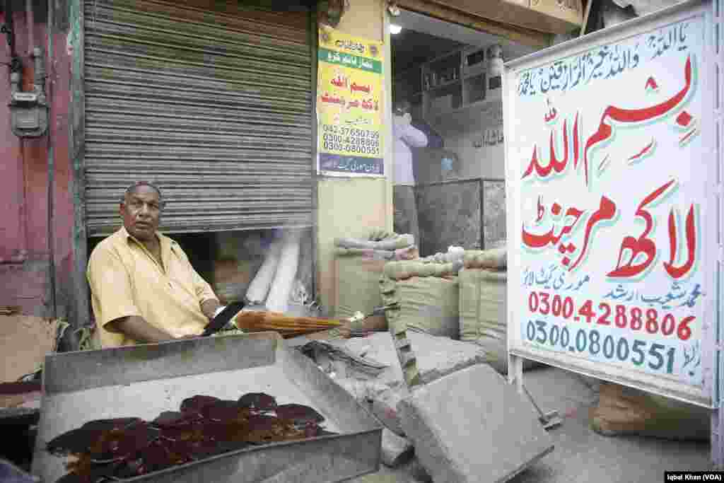 یہ کوئلے کی ایک چھوٹی سی بھٹی کے اوپر بندھے تھیلے سے کچھ مواد نکالنے میں مصروف دکھائی دیتے ہیں۔