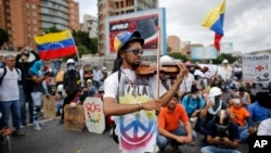 Wuilly Arteaga plays his violin prior clashes with government forces at a march against the government of President Nicolas Maduro in Caracas, Venezuela.