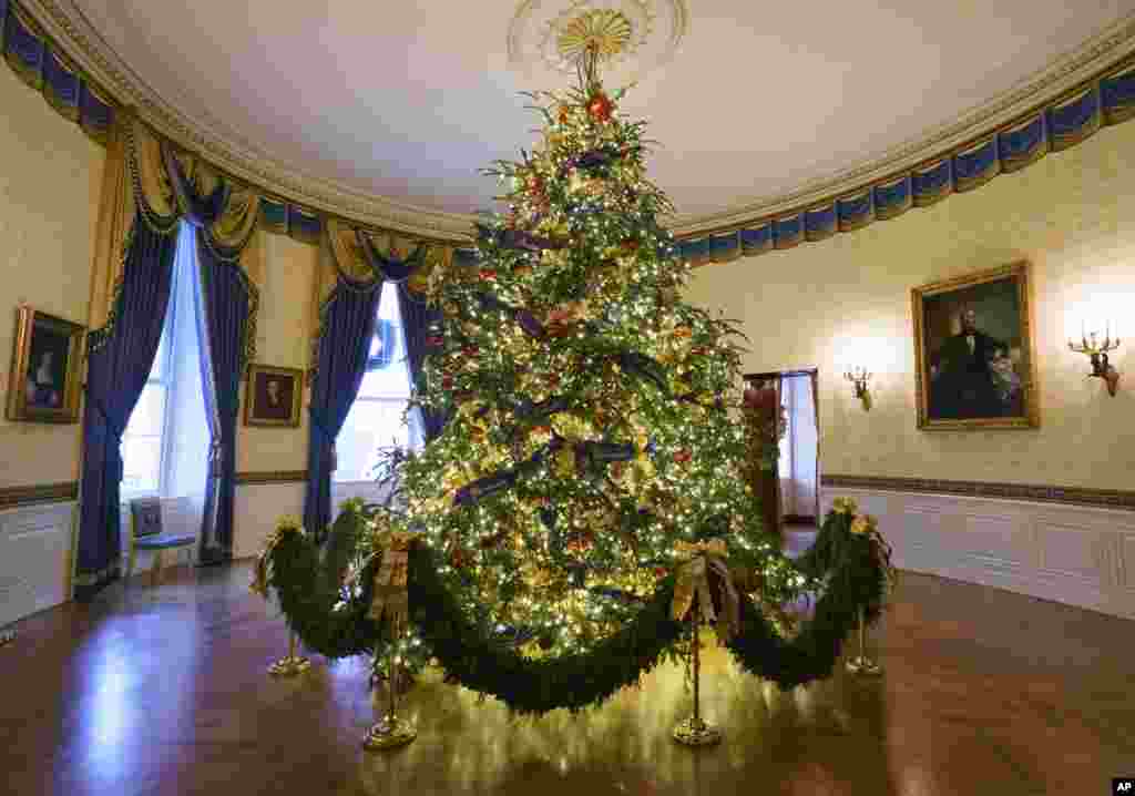 The official White House Christmas tree is seen in the Blue Room during the Christmas press preview at the White House in Washington, Monday, Nov. 26, 2018. The tree measures 18 feet tall and is dressed in over 500 feet of blue velvet ribbon embroidered in gold with each State and territory.&nbsp; (AP Photo/Carolyn Kaster)