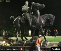 Workers remove the monuments to Robert E. Lee, commander of the pro-slavery Confederate army in the American Civil War, and Thomas "Stonewall" Jackson, a Confederate general, from Wyman Park in Baltimore, Md., Aug. 16, 2017.