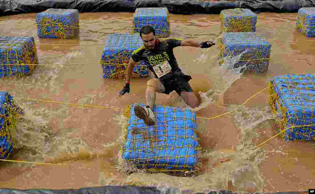 A participant loses his balance while attempting to cross an obstacle during Devils Circuit, an obstacle run event in Bangalore, India.