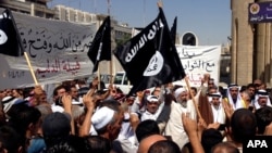 지난 6월 이라크 바드다그 북부 모술에서 ISIL 추종자들이 ISIL 깃발을 흔들며 구호를 외치고 있다. (자료사진)
