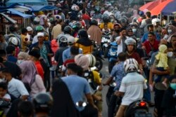 Orang-orang berkumpul di pasar jalanan untuk berbuka puasa selama bulan suci Ramadhan di Banda Aceh pada 14 April 2021. (Foto: AFP/Chaideer Mahyuddin)