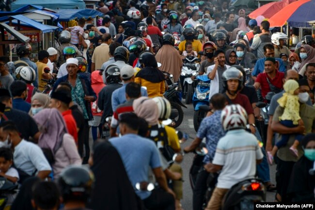 Orang-orang berkumpul di pasar jalanan untuk berbuka puasa selama bulan suci Ramadhan di Banda Aceh pada 14 April 2021. (Foto: AFP/Chaideer Mahyuddin)