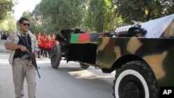 An Afghan security official escorts the coffin containing body of Burhanuddin Rabbani, the slain former President and head of High Peace Council, as the body is transported to the presidential palace in Kabul, Afghanistan, September 23, 2011.