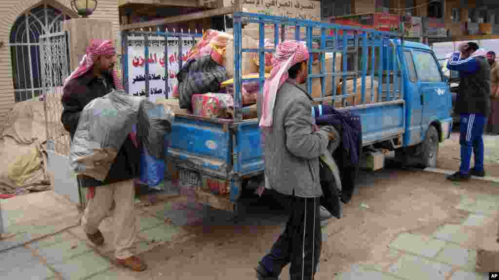 Civilians load their belongings onto a vehicle as they leave their homes after clashes between the Iraqi army and al-Qaida fighters in Fallujah, Jan. 5, 2014. 