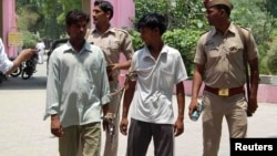 Indian policemen show two men (L and 2nd R), who are accused of gang raping and hanging two girls, to the media at Budaun district in the northern Indian state of Uttar Pradesh, May 30, 2014. 