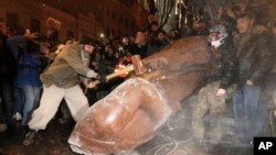 A man with a sledgehammer smashes the toppled statue of Vladimir Lenin in central Kyiv, December. 8, 2013.