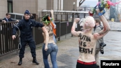 Femen members protest Putin's human rights record, European Union Council building, Brussels, Dec. 21, 2012.