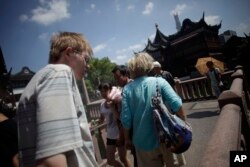 Sejumlah turis asing mengunjungi Taman Yuyuan, salah satu tujuan wisata popular di Shanghai, China, 13 Agustus 2013. (Foto: Eugene Hoshiko/AP Photo)