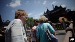 外国游客正在参观中国上海最著名的旅游点之一豫园。(2013年8月13日)