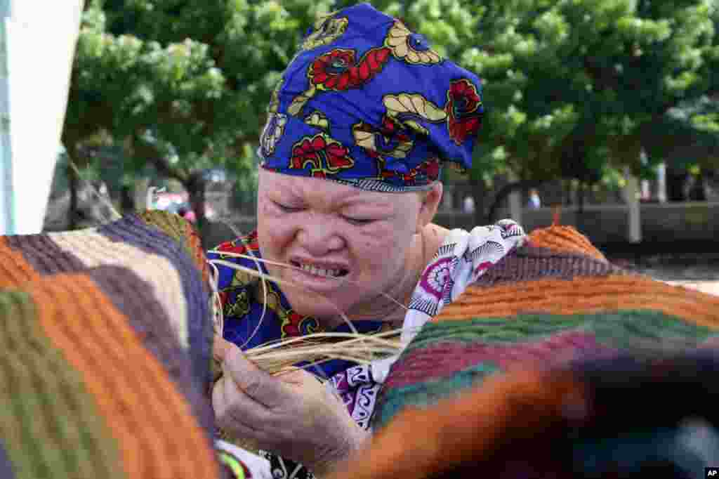 This fie photo shows Muadhani Ramadhani weaving an Africa tradition carpet as part of celebrations to mark World Albino Day in Dares Salaam, Tanzania, 2007.