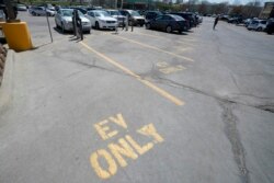 Four electric vehicle charging spots stand empty in a grocery story parking lot in Lawrence, Kan., Monday, April 5, 2021.