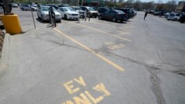 Four electric vehicle charging spots stand empty in a grocery story parking lot in Lawrence, Kan., Monday, April 5, 2021.