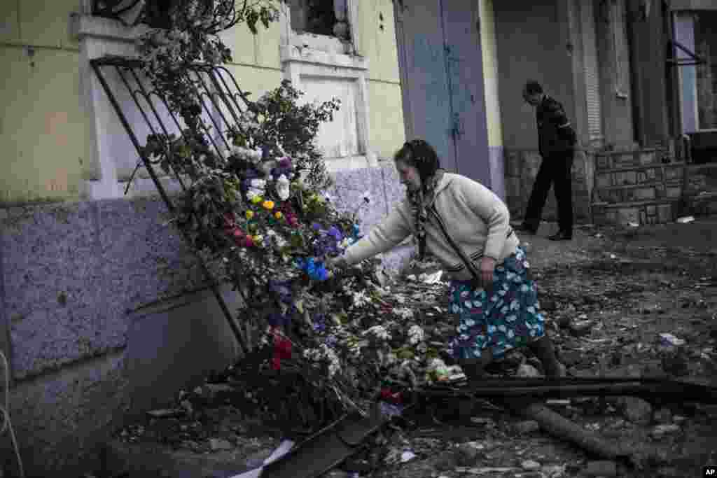 A woman puts flowers outside a police station where people died&nbsp;on May 9 during fighting between government forces and insurgents, in Mariupol, May 11, 2014.