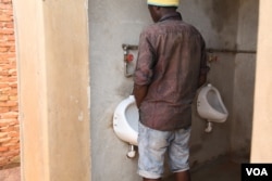 Peeing is a source of wealth to most residents of Area 25A in the capital Lilongwe - this man is peeing for a purpose inside the urine harvesting plant. (L. Masina/VOA)