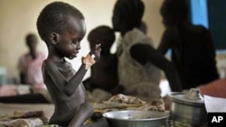 Two-year-old Nyagod Kuel attempts to eat on her bed in a hospital ward in Akobo, southeastern Sudan, December 2010. The U.N. had once called the region the "hungriest place on earth." (File)