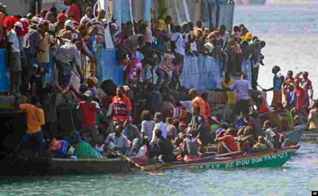 Locals board a ship ready to depart to Jeremie, about 200 kilometers (130 miles) from Port-au-Prince, at the La Saline harbour in Port au Prince, 20 Jan 10 - AFP