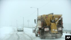 Driver struggles to climb overpass on Hinkleville Road as a snow plow approaches, Paducah, Kentucky, Dec. 6, 2013.