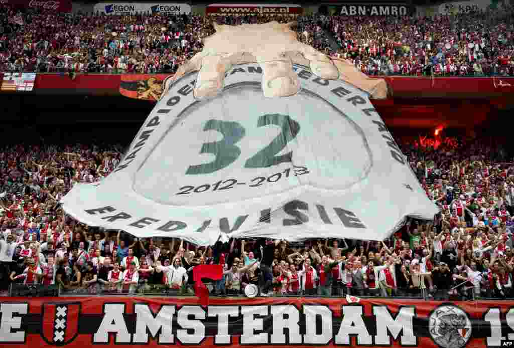 Ajax Amsterdam supporters celebrate after winning a Dutch Eredivisie football match against Willem II Tilburg in the Amsterdam Arena, the Netherlands. 