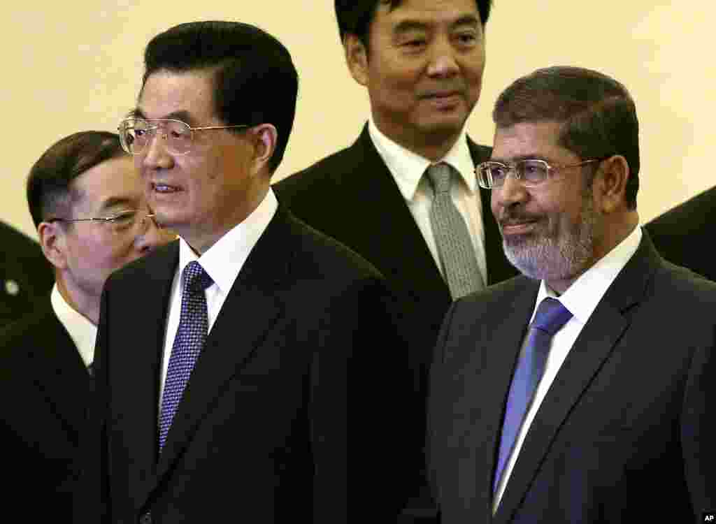 Le président égyptien Mohammed Morsi, à droite, et le président chinois Hu Jintao, deuxième à gauche, prennent part à une cérémonie au Grand Palais du Peuple à Beijing mardi, 28 août 2012.