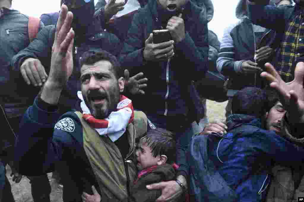 A man reacts as children cry during clashes outside a refugee camp in the village of Diavata, west of Thessaloniki, northern Greece, April 6, 2019.