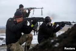FILE - Ukrainian servicemen fight at their position near Lysychansk, in the Luhansk region, Jan. 29, 2015.