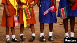 FILE - Young girls with U.S. and Kenya flags wait to greet U.S. Ambassador to Kenya Robert Godec in Nairobi, Kenya, March 10, 2018. 