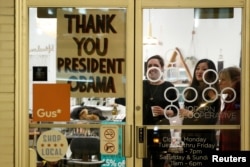 A shop has a sign in the window reading thank you to U.S. President Barack Obama, who was making a stop nearby on his way to deliver his farewell address in Chicago, Ill., Jan. 10, 2017.