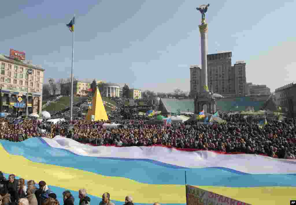 People hold Ukrainian, Crimean and Crimean Tatar flags during rally in support of Ukraine's territorial integrity, in Kyiv's Independence Square, March 23, 2014.