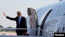 U.S. Secretary of State John Kerry waves as he boards his plane at Andrews Air Force Base in Maryland on his way to Doha, June 21, 2013. 