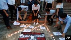 FILE - Students from the University of the Philippines place messages around the figure "74" during a candle-lit protest in remembrance of the alleged 74 minors killed in Duterte's so-called war on drugs, March 27, 2019, Manila.