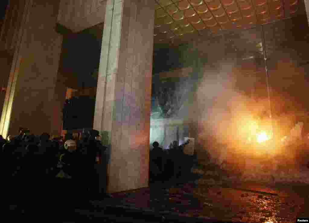 Anti-government protesters try to enter the Ukrainian House where riot police were located during a rally in Kyiv, Jan. 26, 2014.