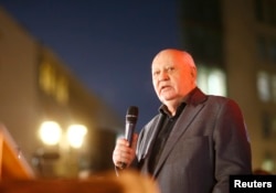 FILE - Former Soviet President Mikhail Gorbachev visits the former Berlin Wall border crossing point Checkpoint Charlie, in Berlin, November 7, 2014.